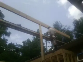 Carpenter setting a ridge beam over a new addition frame — Ice Dam Removal by Roofing Brothers in Olympia Fields