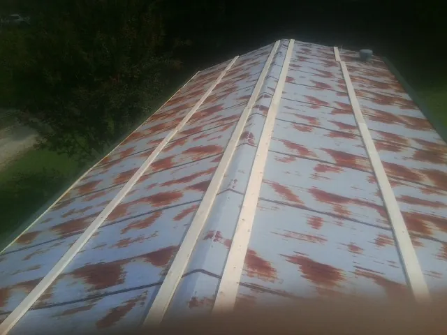 Rusted metal roof panels with new wood purlins before replacement — Storm Damage Roof Repair in Olympia Fields by Roofing Brothers