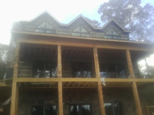 Dormers and porch framing on a large log home under construction — Roof Coating work by our crew in Olympia Fields