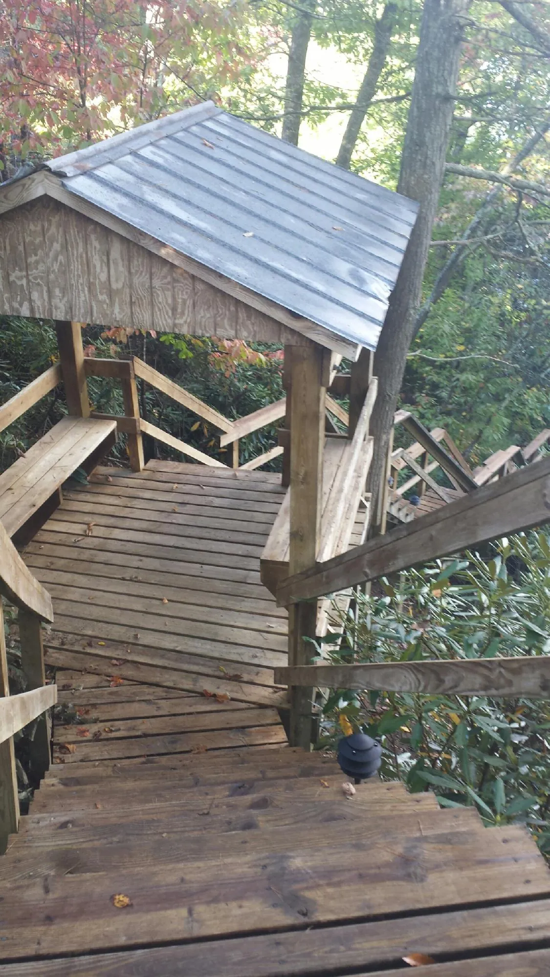 Metal roofed shelter over wooden steps on a wooded walkway — Skylight Repair & Installation work by our crew in Olympia Fields