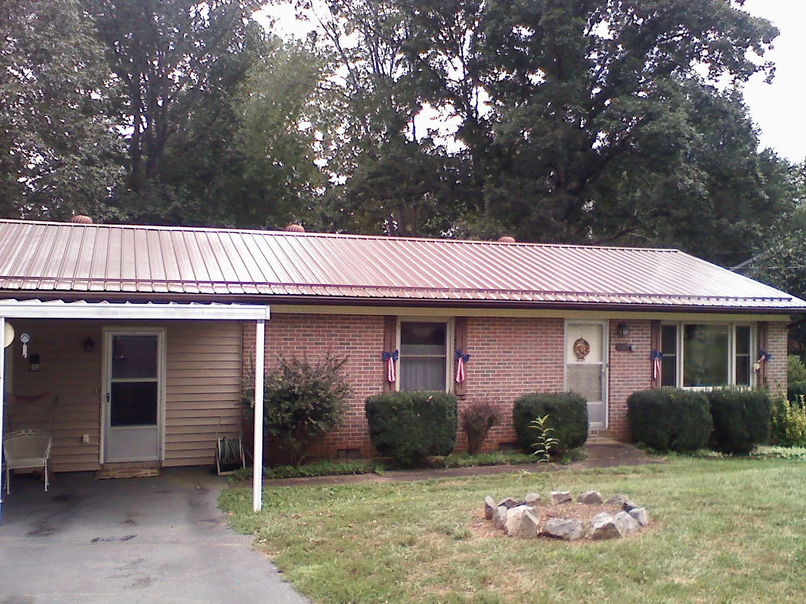 Bronze metal roof and carport on a brick ranch home — Roof Repair work by our crew in Olympia Fields
